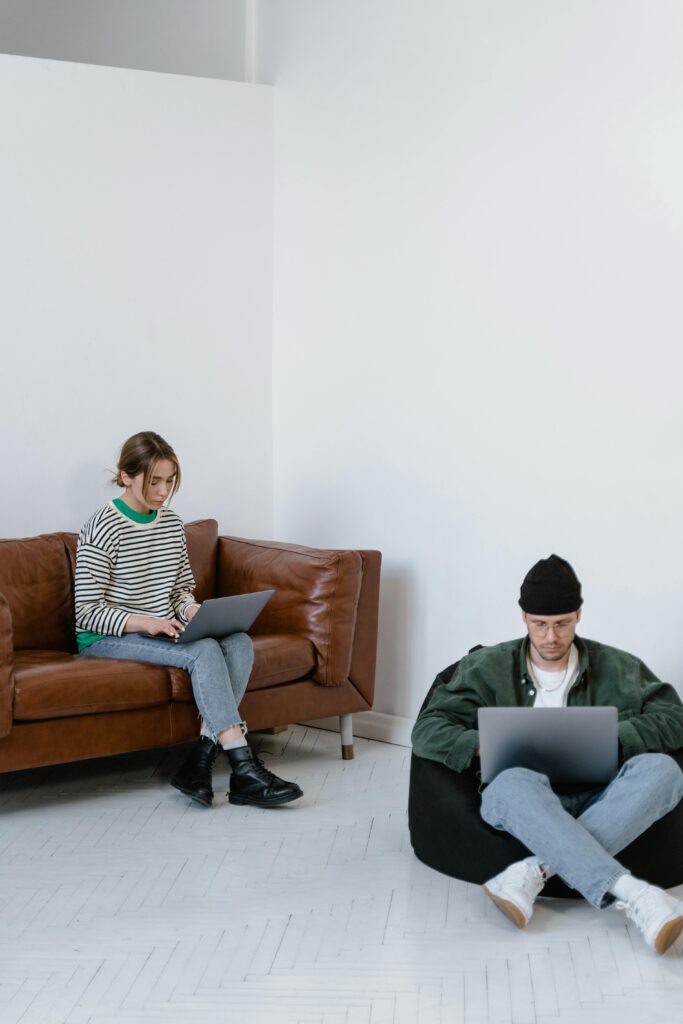 Two adults focused on laptops in a contemporary office setting, perfect for business themes.